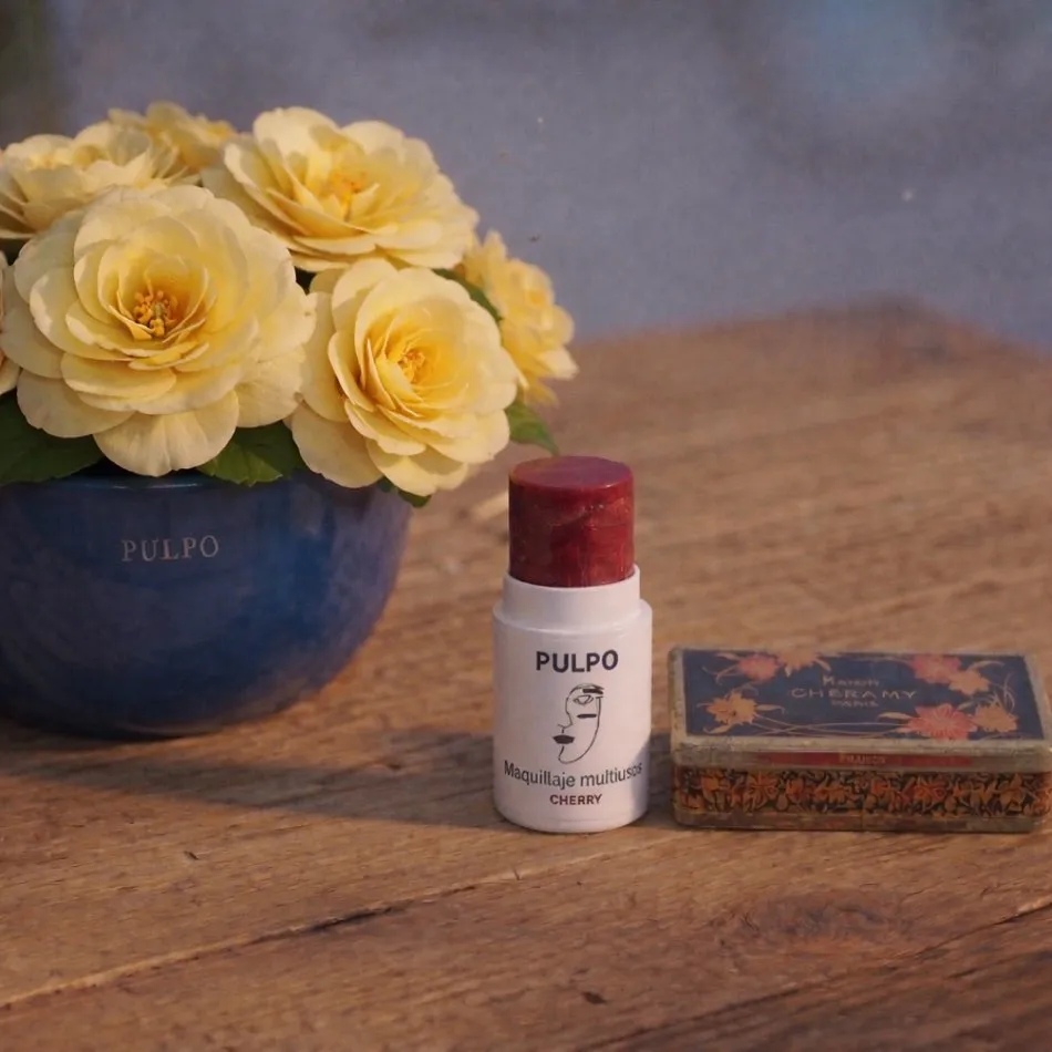 Maquillaje multiusos Cherry junto a una lata antigua